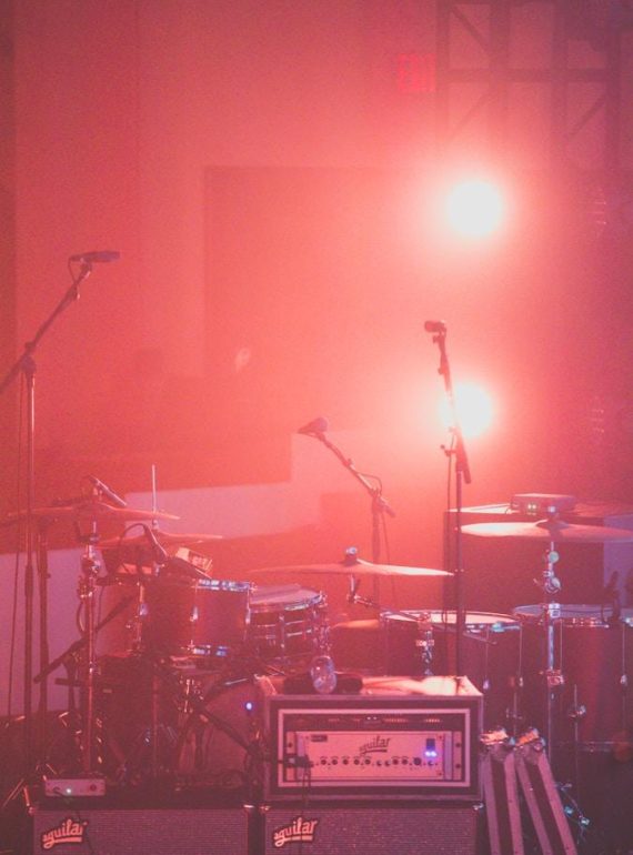 red drum set besides microphone stands